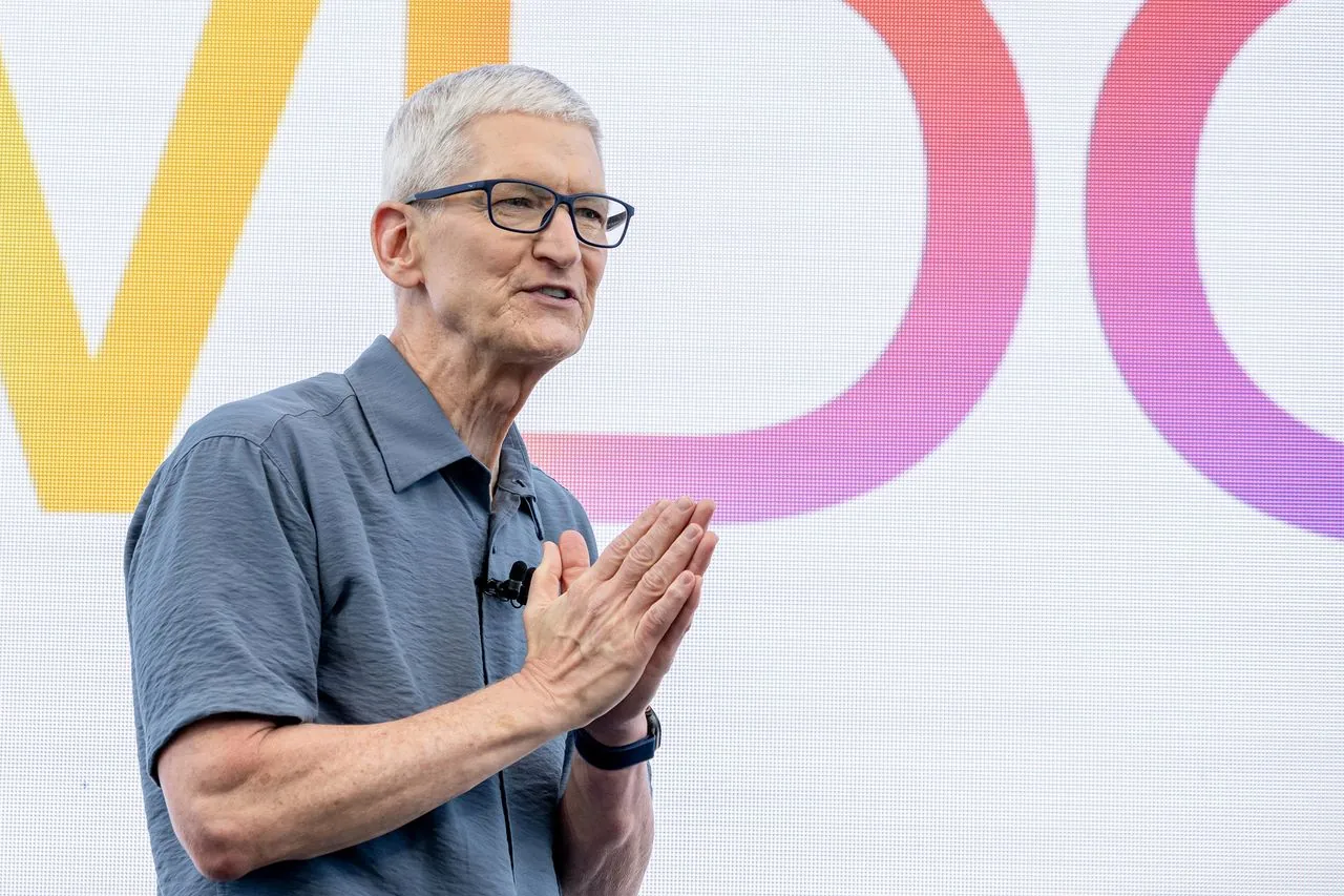 Tim Cook, CEO de Apple, durante un evento con el logotipo de WWDC de fondo.